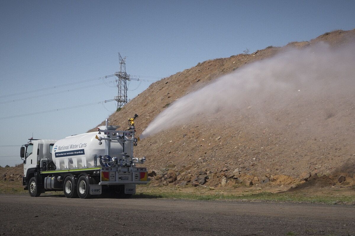A 13,000-litre CivMaster EXM FVZ CANbus hydraulic water truck saturates an embankment using its side batter spray while in motion.