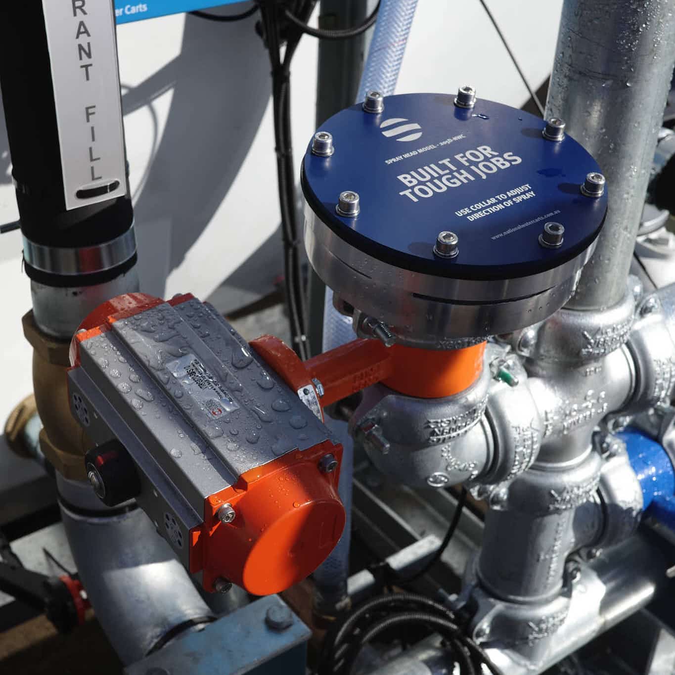 A close-up of a 205-D spray head fitted to the pipe manifold of a slip-on water cart by National Water Carts.