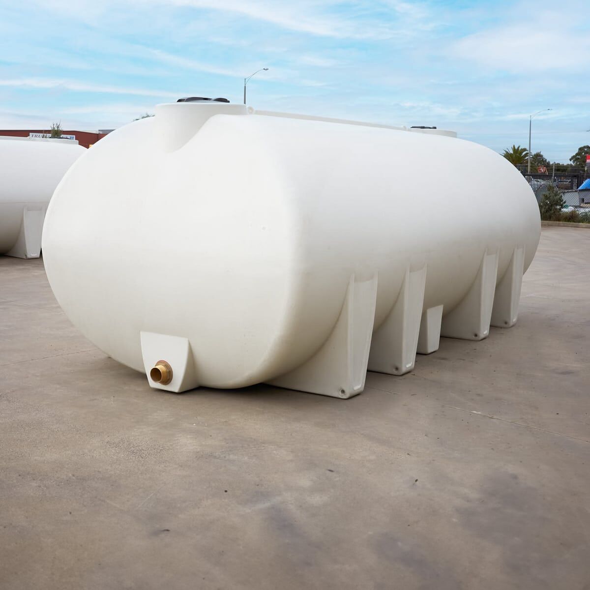 A 13,000-litre white poly cartage tank with a brass tank outlet for water transfer.